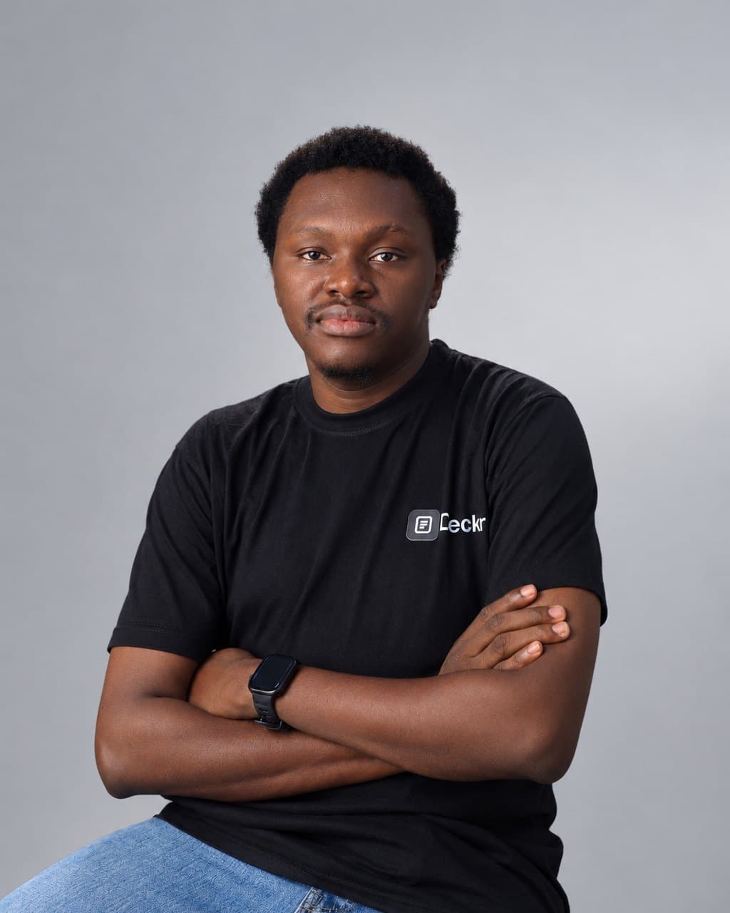 Tolulope Adesodun in a black Deckr T-shirt, arms crossed